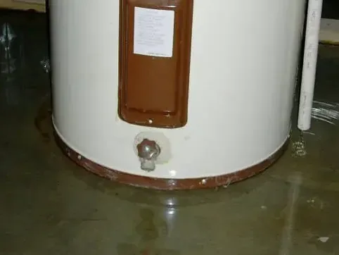 Leaking tank-style water heater inside a home